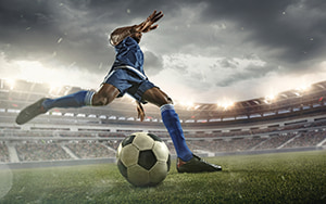 a professional soccer player kicks a ball in a packed stadium