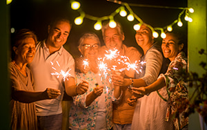 Group adults, teens and kids celebrating with sparklers